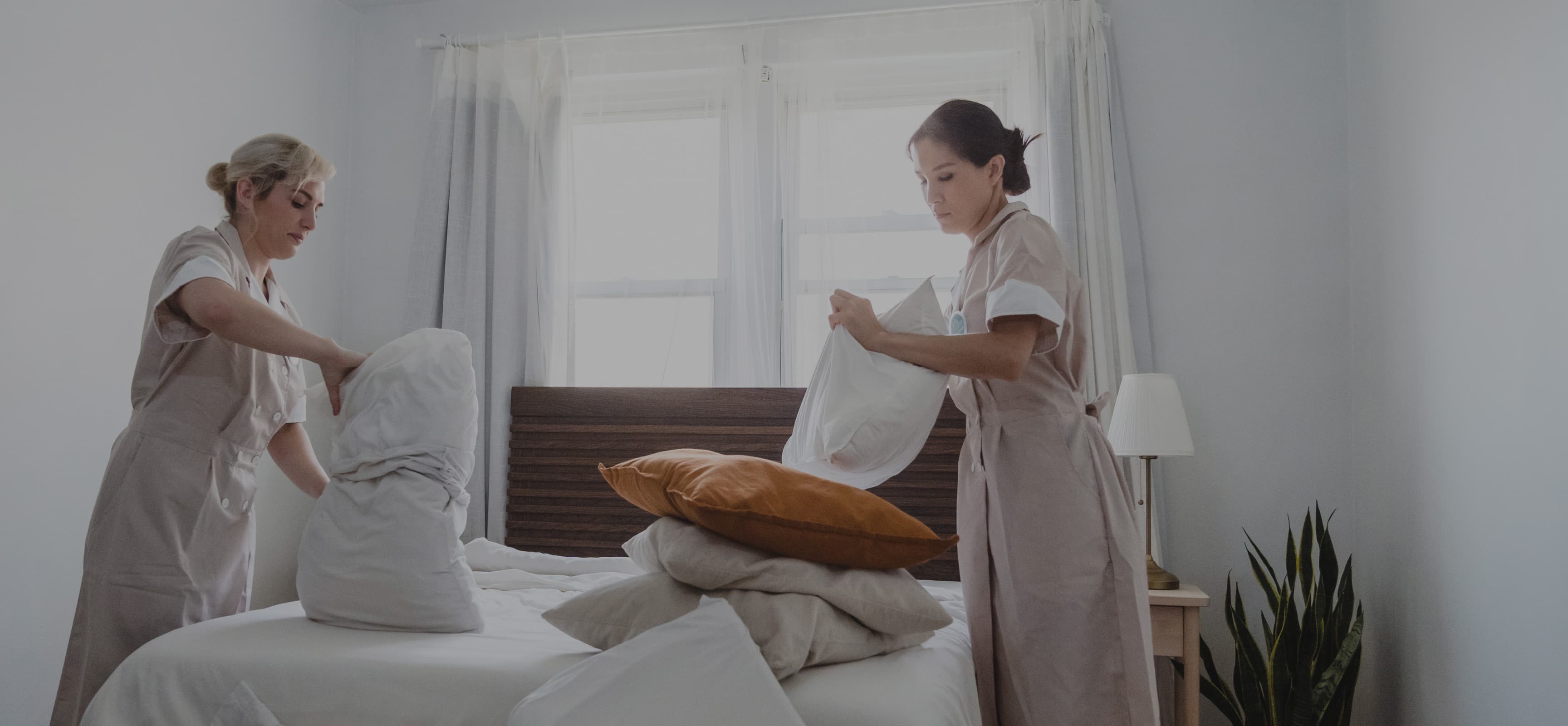 A woman performing bedroom cleaning